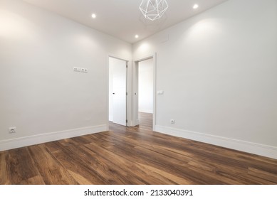 Freshly Painted Empty Living Room With Dark Wood Floorboards And Recessed Lighting In The Plaster