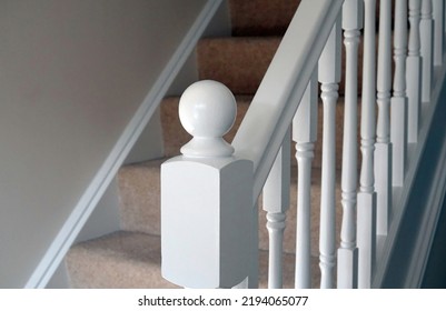 A freshly painted white staircase with carpet on the stairs in a modern home. - Shutterstock ID 2194065077