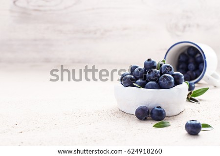 Freshly picked blueberries in a white vintage ceramic bowl. Selective focus, Free text space.