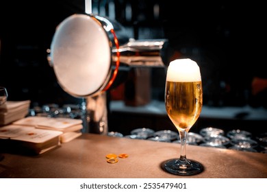  A freshly poured beer with a frothy head stands on a counter next to a beer tap.  - Powered by Shutterstock