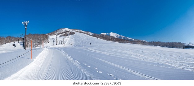 Freshly pressed piste in a quiet ski resort at early morning on a clear day (Niseko Moiwa, Hokkaido, Japan)