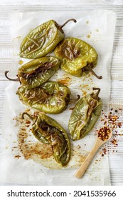 Freshly Roasted Green Peppers With Skin Seasoned With Chili Spices On Baking Paper, Messy Food Preparation Top View