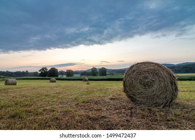 Freshly Rolled Bales Of Hay Rest On A Field At Sunrise In Sussex County, NJ, Late Summer