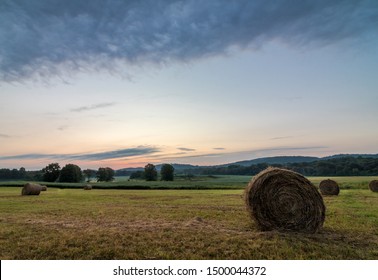 Freshly Rolled Bales Of Hay Rest On A Field At Sunrise In Sussex County, NJ, Late Summer