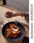 Freshly served pasta with rich meat sauce and glass of red wine in elegant ceramic plate. Authentic Italian cuisine in modern restaurant setting with wine pairing