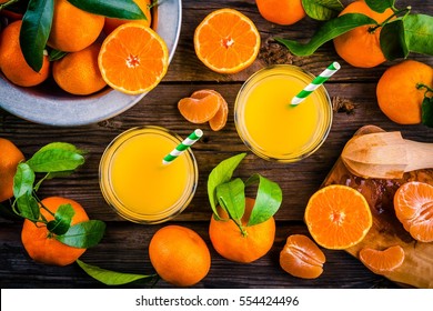 freshly squeezed tangerine juice in glass on rustic wooden background
