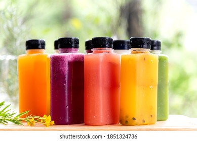 Freshly summer fruit and berries cold press juice serve in grass bottle in ther morning nature background.