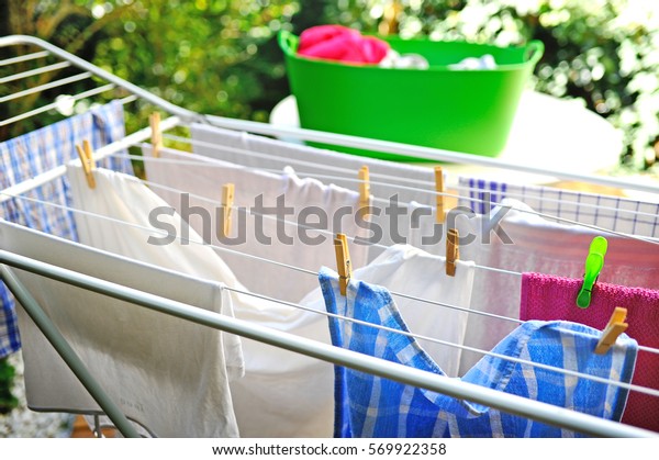 Freshly\
washed clothes drying outdoor on drying\
rack