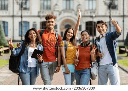 Freshmen Orientation Concept. Group Of First Year Students With Workbooks Posing Together Outdoors, Happy Multiethnic Young People Standing Near University Building And Smiling At Camera Stock foto © 