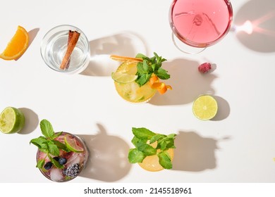 Freshness summer cocktails, lemonade, mai tai, blackberry mojito with lime on white background with sunny shadow. Summer beverage. View from above.