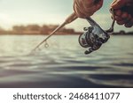 Freshwater fishing in summer. Spinning reel on a spinning rod in the hands of a fisherman.