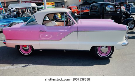 FRESNO, UNITED STATES - Apr 03, 2021: A Side Photo Of A Reallycute Pink And White Nash Classic Car With Pink Rims In A Car Show Outside On A Sunny Day