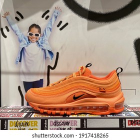 FRESNO, UNITED STATES - Feb 10, 2021: A Photo Of An All Orange New Nike Shoe For Women On Display In Store With Cool Graphics In Background And On The Stand In 2021