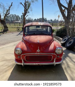 FRESNO, UNITED STATES - Feb 18, 2021: A Photo Of A Front View Of A Really Rare Small British Minor 1000 Classic Car Parked Outside On Driveway With A Blue Sky   Trees In The Background