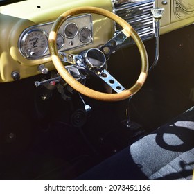 FRESNO, UNITED STATES - Oct 09, 2021: A closeup photo of a steering wheel inside a gold custom designed 1950 Ford Model F1 with grey seat covers at car show in Ca  2021