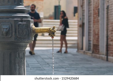 Freudian allusions. Leaking tap, young woman in miniskirt  looking in the wake of passing by man. Venice, Italy.