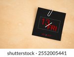 Friday 13th calendar date for December 2024 with paper clip on brown paper background.