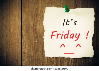 It's Friday - Hand writing text on a piece of paper on wood background