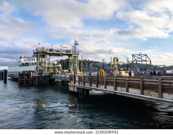 Friday Harbor, WA USA -\
circa November 2021: View of the Tillikum Washington State Ferry\
docking on San Juan Island, about to unload its passengers on a\
sunny day.