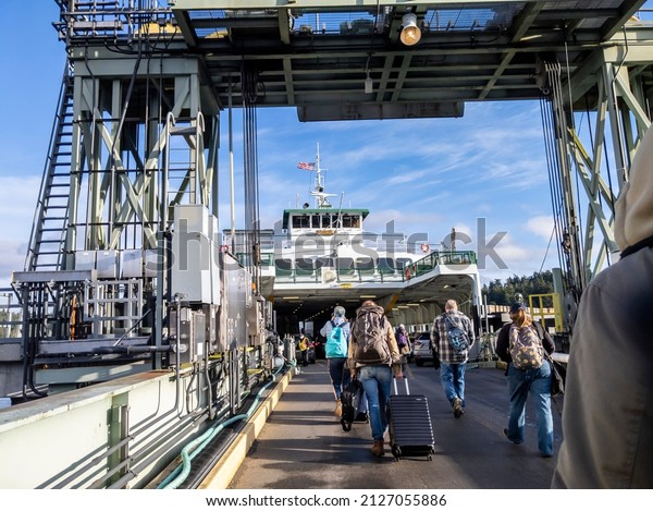 Friday Harbor, WA USA - circa November 2021: View of\
people lined up, waiting to board the Tillkum Washington State\
Ferry on a sunny day.