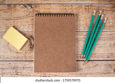Fridge stickers, notepads and green pencils on a brown wooden background. Stationery, notes and organizer for business, motivation and training