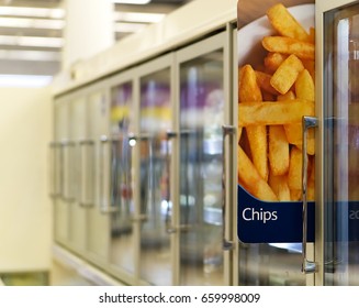 Fridge/freezer Aisle In Supermarket With Chips Ad On Display In Foreground  