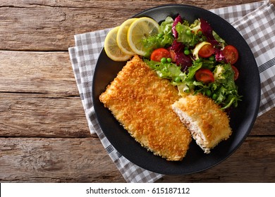 Fried Arctic Char Fish Fillet In Breadcrumbs And Fresh Vegetable Salad Close-up On A Plate. Horizontal View From Above
