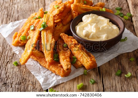 fried baby corn with green onions and creamy sauce close-up on a table. horizontal
