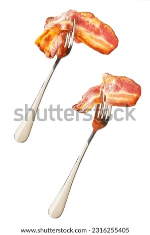fried bacon strips on a fork isolated on white background.