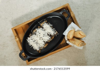 Fried Bananas With Chocolate Cheese Topping On A Black Oval Plate In The Photo From Above