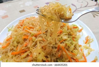 Fried Bean Thread Or Cellophane Noodles With Shredded Carrot And Cabbage. The Ingredients Are Usually Scoop Up With The Help Of A Fork. 