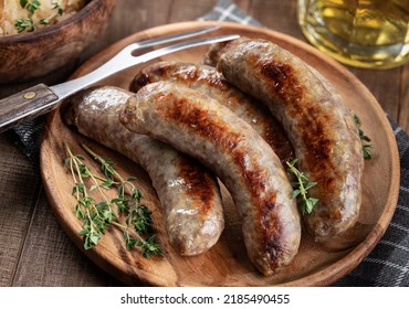 Fried Bratwurst Garnished With Thyme On A Plate On A Rustic Wooden Table