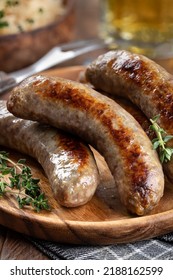 Fried Bratwurst Garnished With Thyme On A Plate On A Rustic Wooden Table