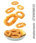 Fried breaded squid rings falling onto plate against white background