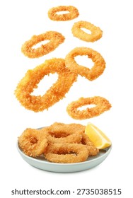 Fried breaded squid rings falling onto plate against white background