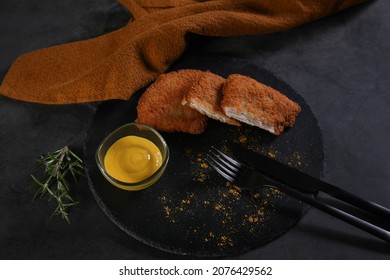 Fried Breaded Tenderloin Served On A Black Plate