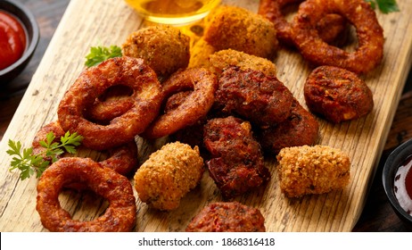 Fried Buffalo Onion Rings, Tater Tots And Sweetcorn Fritters With Ketchup And Beer. Party Take Away Food