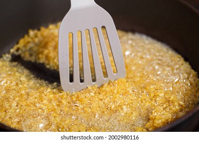 Fried Bulgur In A Frying Pan. Caramel Flavored Wheat Grains Stirring With A Kitchen Spatula In Boiling Oil