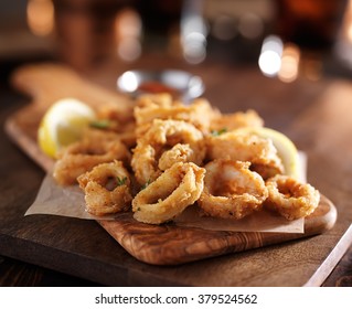 fried calamari rings on wooden tray with dipping sauce - Powered by Shutterstock