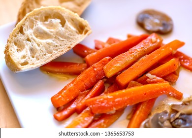 Fried Carrots, Mushrooms And Garlic. Large Juicy Slices Of Sauteed Vegetables And Bread On A Plate. Cooked Sliced Carrots And Mushrooms. Vegetarian Food. Soft Focus. Top View.