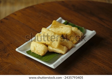 Fried cassava on rectangular plate. Plate on the round table. Singkong goreng