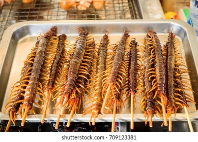 Fried Centipede In Wooden Stick As Snack Street Food In China , This Image Is Weird Food Concept.