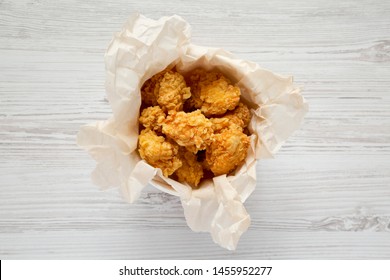 Fried Chicken Bites In A Paper Box Over White Wooden Background, Overhead View. Flat Lay, Top View, From Above. 