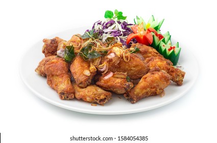 Fried Chicken with Crispy Thai Herbs (Kaffer,red onions, Lemon Grass) Thai Food Asian Style decorate with carved cucumber,chilli and vegetable Style side view