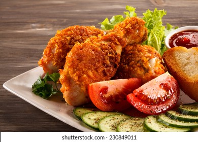 Fried chicken drumsticks and vegetables