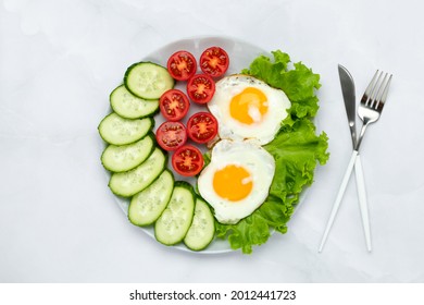 Fried Chicken Eggs With Vegetables On A Gray Table. Breakfast Concept. Top View. Food Background In Morning. Fresh Sliced Cucumbers And Tomatoes. Flat Lay Composition. Overhead View.