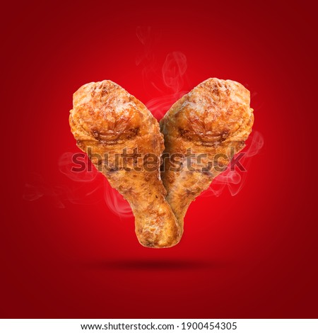 Fried chicken in form of hearts on red background.