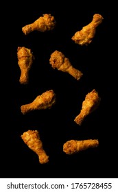 Fried chicken legs flying isolated on a black background