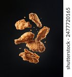 Fried Chicken in mid-air falling on black background