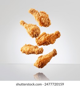 Fried Chicken in mid-air falling on white background